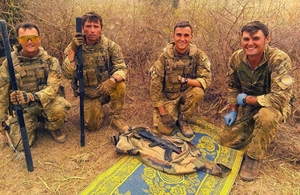 British peackeepers pose with one of the AK47 rifles found (MoD Crown Copyright)